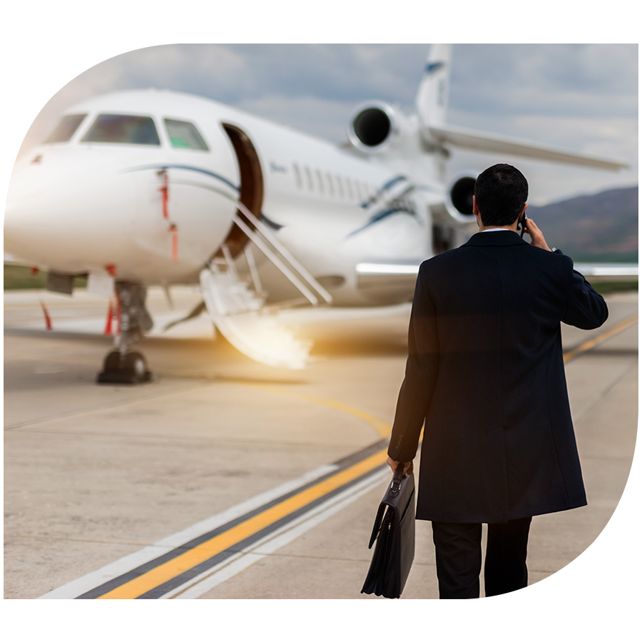 A man wearing a suit and carrying a briefcase approaching a private jet