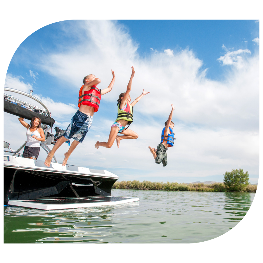 children jumping off boat into a lake