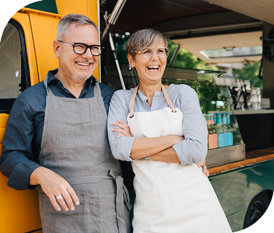 small business owners smiling in front of food truck