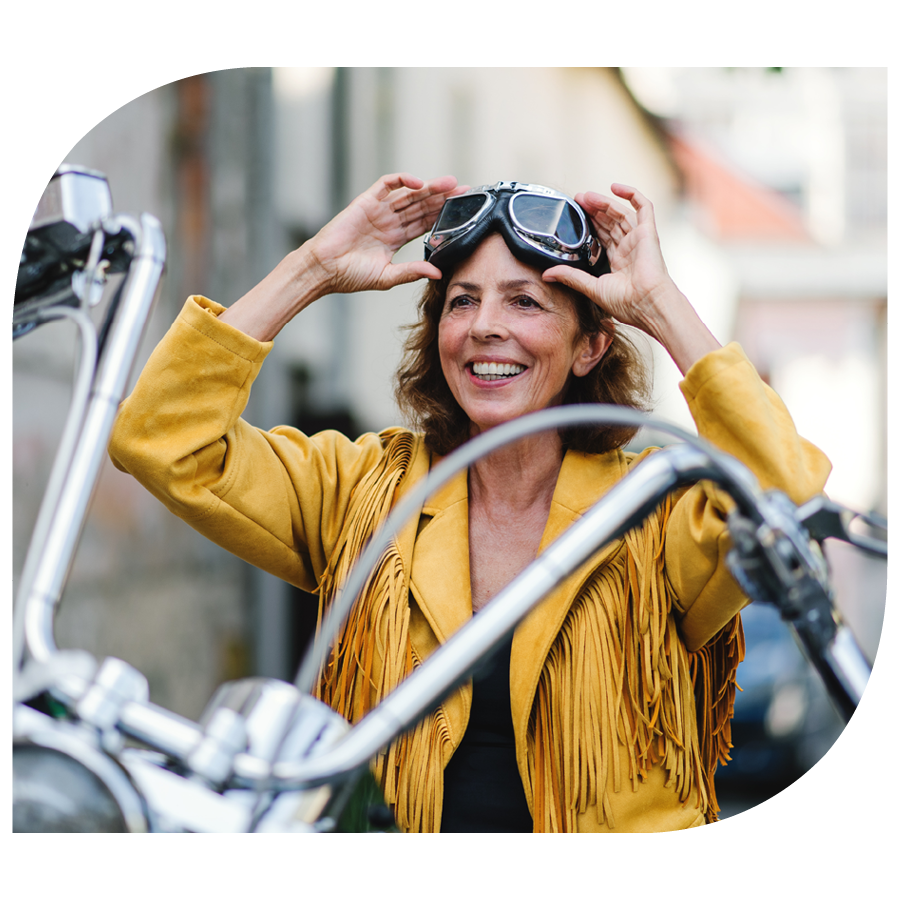 woman on motorcycle smiling while putting on goggles