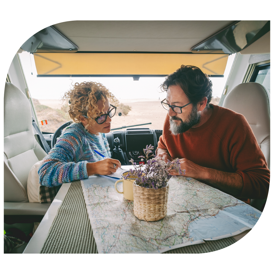 middle aged couple in rv planning trip with paper map