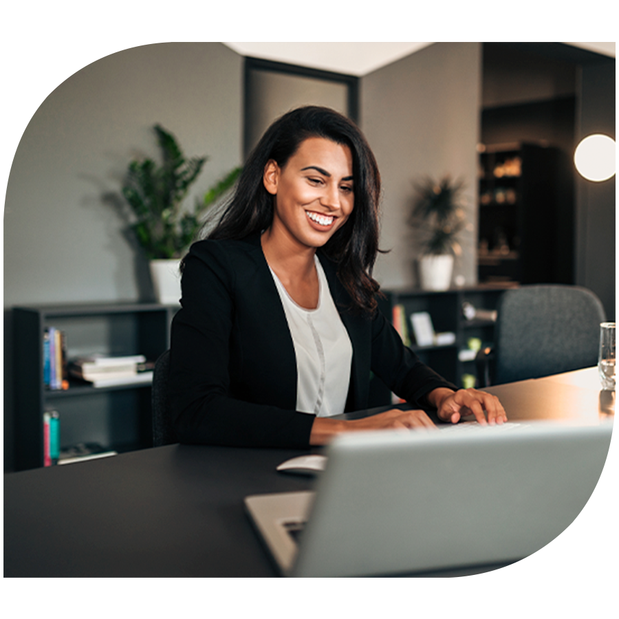 woman smiling working on laptop in corporate office