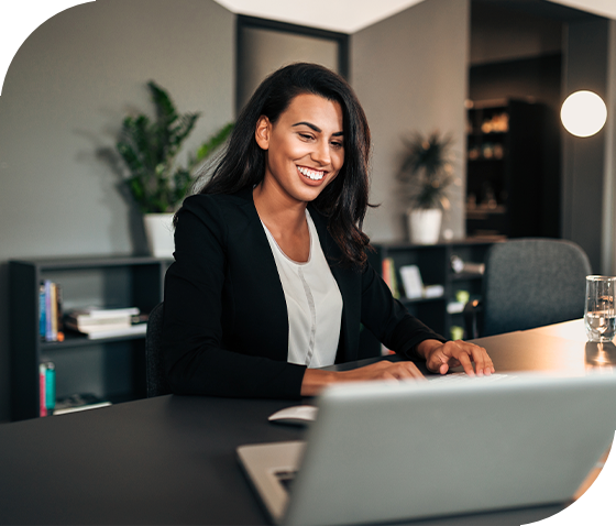 woman smiling working on laptop in corporate office