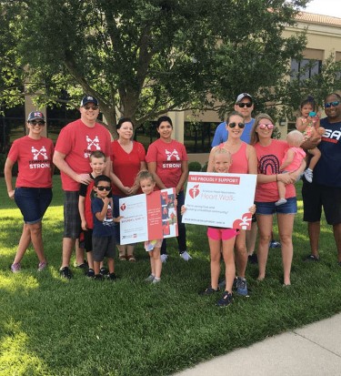 simmons associates and families posing for group picture at America Heart Association event