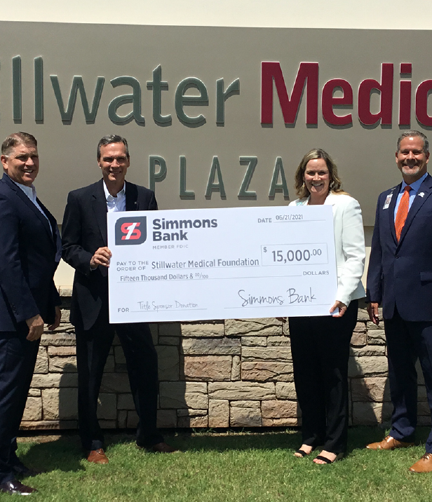 Two people holding Simmons Bank donation check for Stillwater Medical Foundation