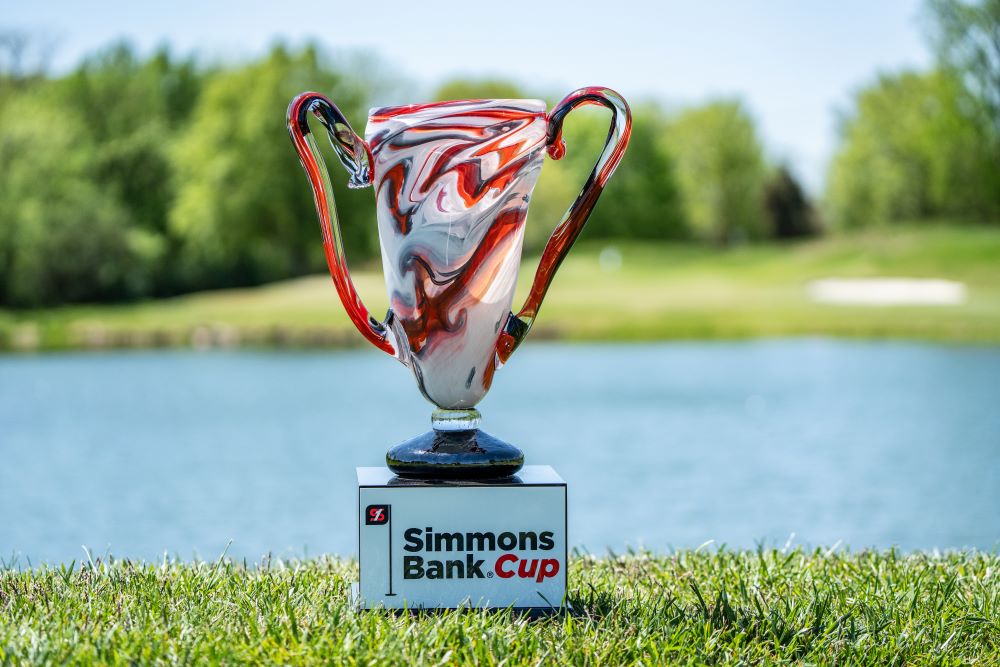 A red, blown glass Simmons Bank Cup trophy on display on a golf course