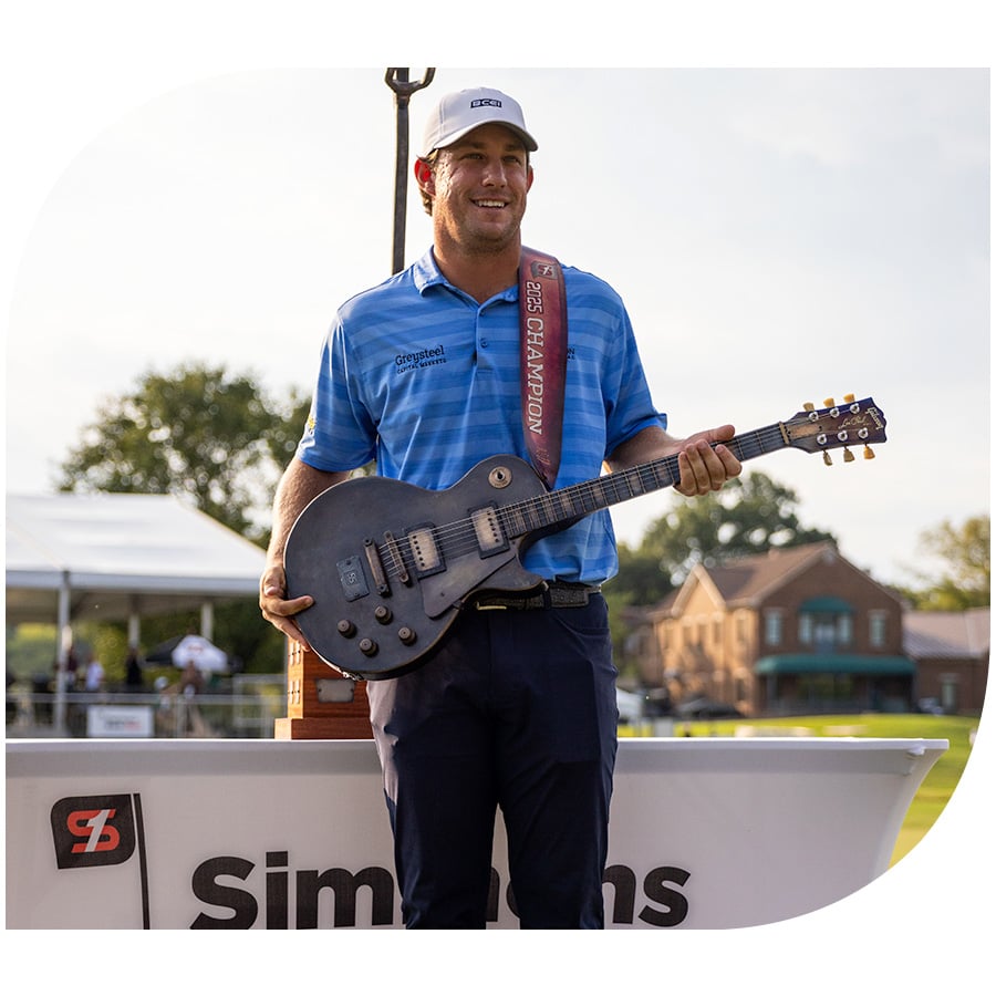 Zach Bauchou poses with the 2025 Simmons Bank Open guitar shaped trophy