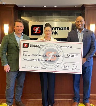 simmons associate posing with donation check for American Cancer Society