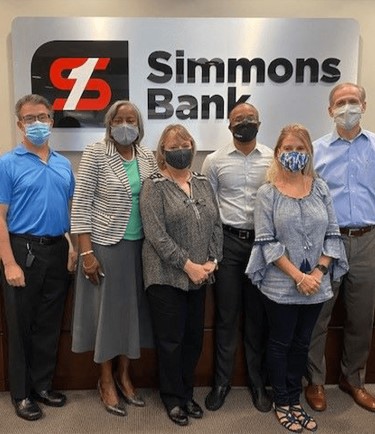 six simmons associates posing in front of Simmons Bank logo