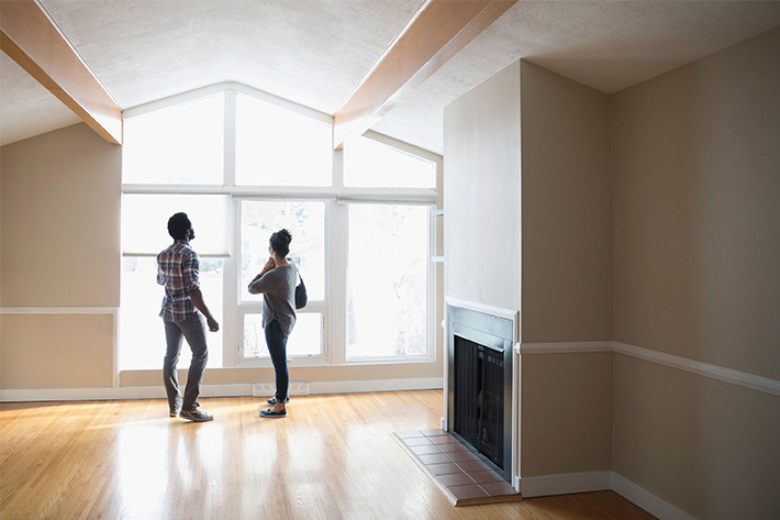 Couple looking through the window of a new house